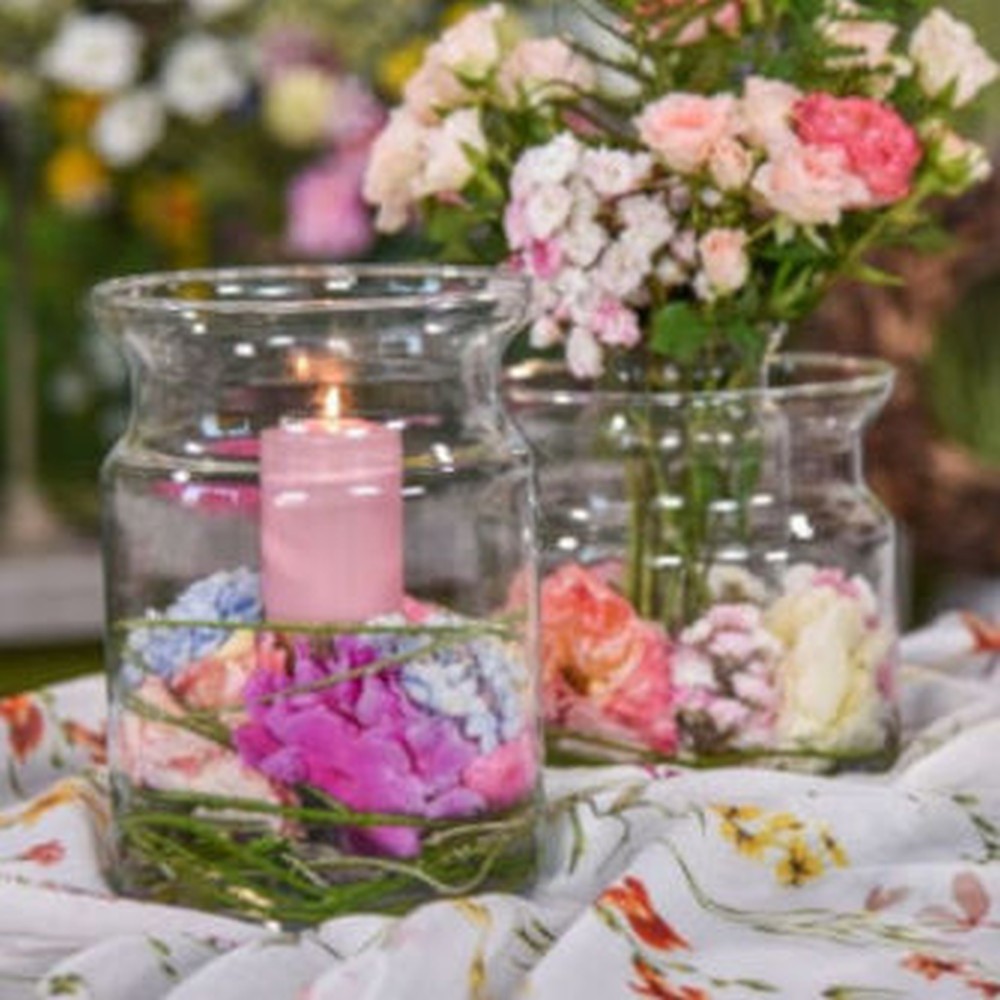 Roses et bougies dans un verre photophore